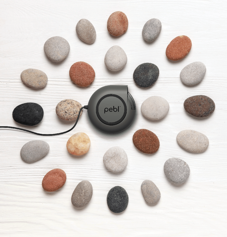 Pattern of natural multicolored pebbles on white wooden background. Spa decoration. Meditation and relaxation concept. Flat lay, top view. Copy space