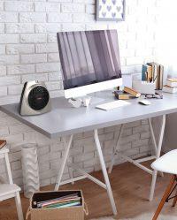 lifestyle of a vh203 personal heater on a desk next to a desktop