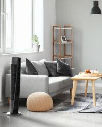 Vornado OSC84 41" Oscillating Tower Circulator plugged in next to a gray sofa