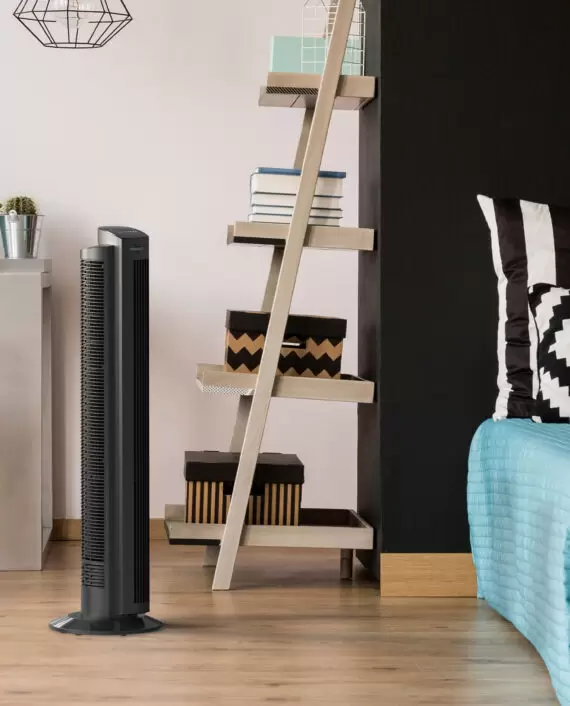 Lifestyle of Vornado OZI42 42" Oscillating Tower Circulator on wood floor in a bedroom