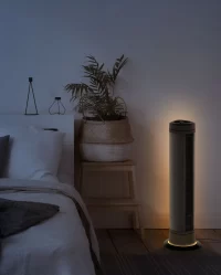 Lifestyle image of ARA next to a bed. The room is dark, showing off ARA's ambient light feature.