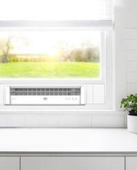 White Vornado Portal Lifestyle image. Portal mounted in the window of a kitchen with a plant, countertop, and surrounding wall visible.