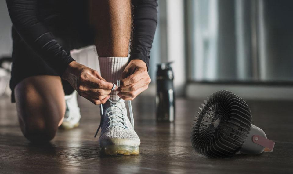 Fly Move Portable Comfort Fly Move next to an athlete tying his shoe in a gym.