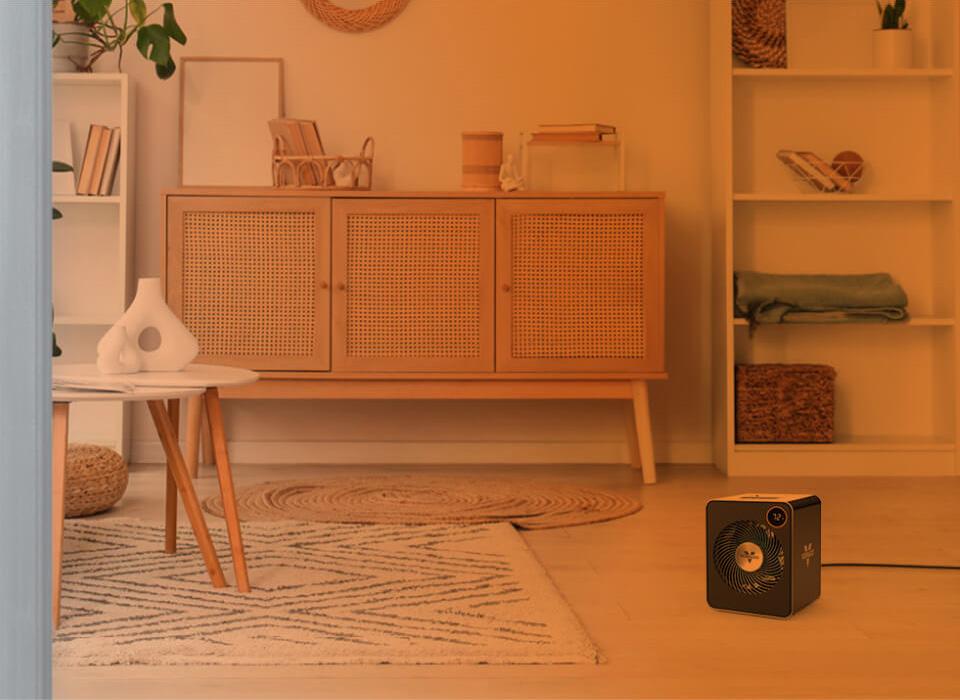 VMHi600 Heat Circulation Part of a living room seen through an open door with an orange gradient to show whole room heat circulation. VMHi600 on the floor.