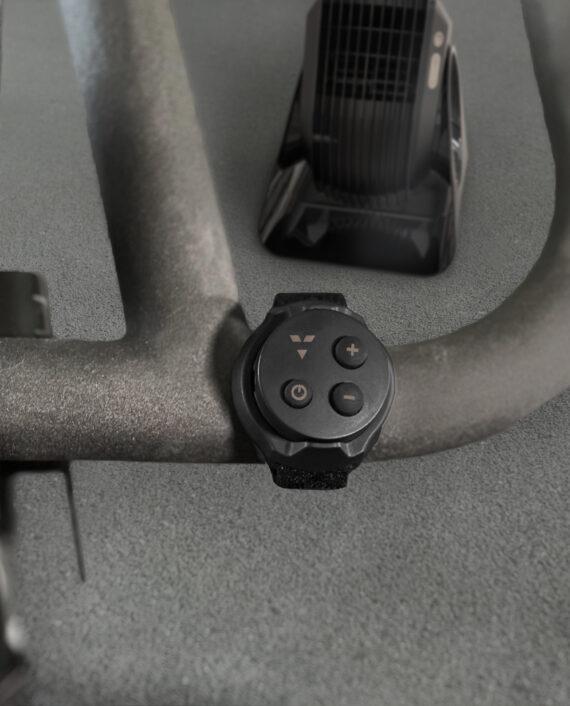 Vornado FLY MAX Remote attached to a stationary bike handle in front of a Vornado Fly Max