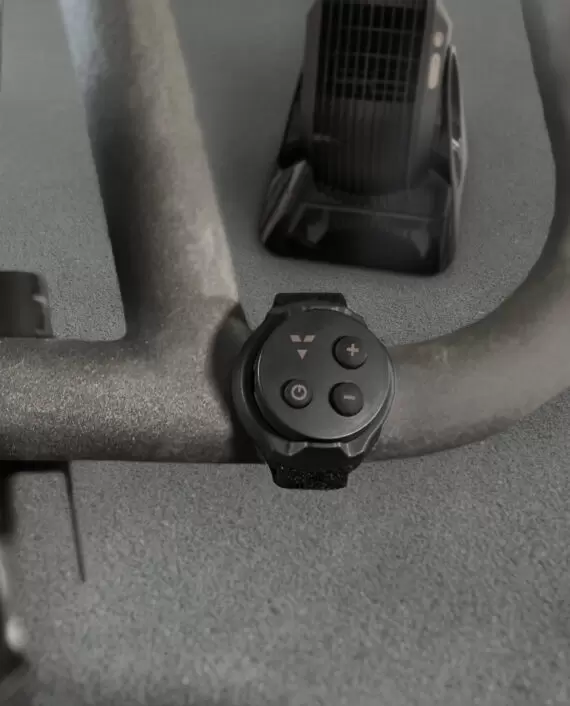 Vornado FLY MAX Remote attached to a stationary bike handle in front of a Vornado Fly Max
