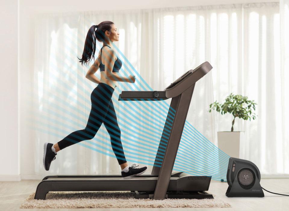 FLY MAX Intense Airflow Woman exercising on treadmill at home while FLY MAX blow cool air at the front of the machine.