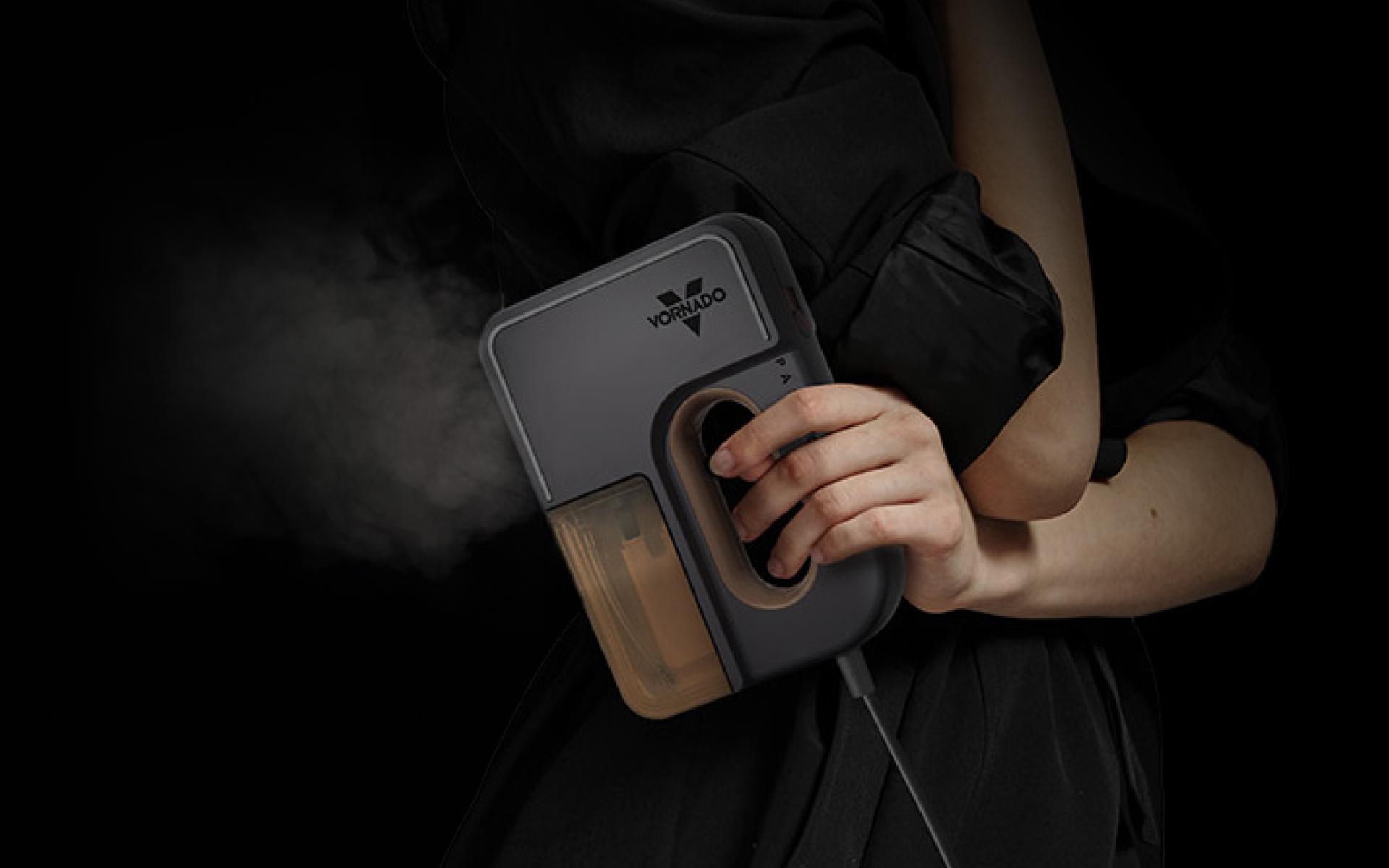 Woman holding the passport handheld garment steamer. The shot is almost completely dark and steam is coming out of passport.