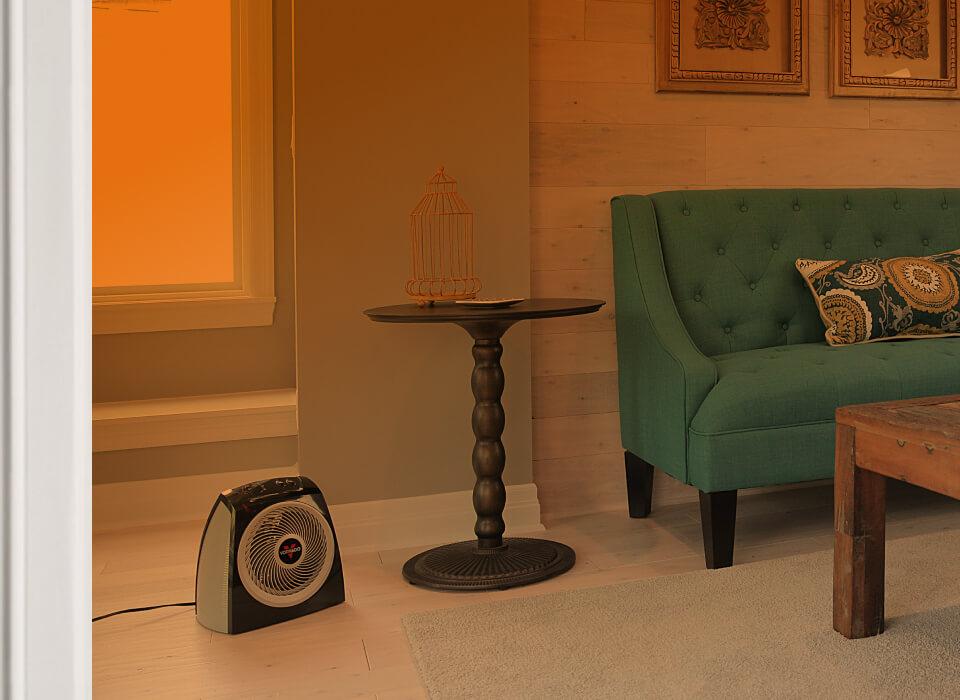 VH10+ Whole Room Part of a living room seen through an open door with an orange gradient to show whole room heat circulation. VH10+ is on the floor.